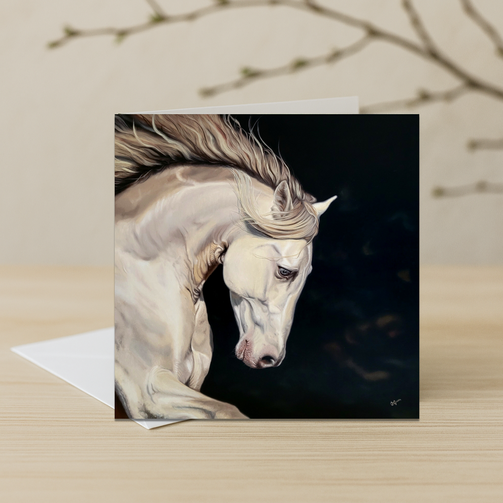 Greeting card with a painting of a white horse on a dark background, placed on a wooden surface.