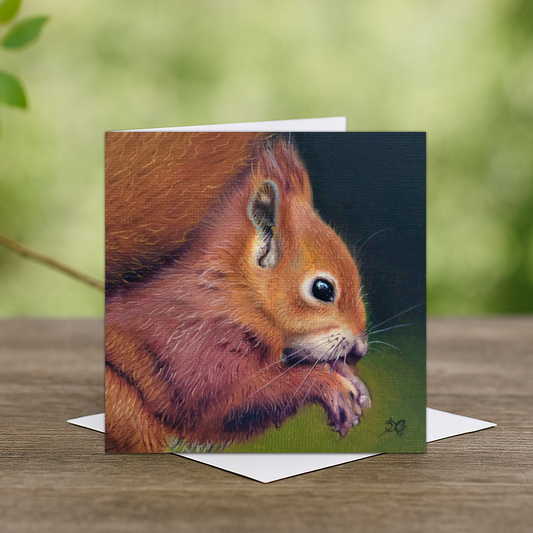 A greeting card of a little red squirrel eating its meal 
